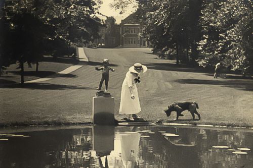 Elisabeth Severance Allen Prentiss pictured with a dog behind the lily pond on the grounds of Glen Allen