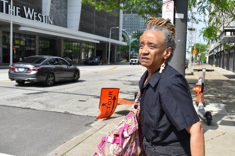 Marvetta Rutherford, a spokesperson for the advocacy group Clevelanders for Public Transit, prepares to cross the street in downtown Cleveland as she walks roughly 30 minutes to her temporary job at FirstEnergy Stadium.