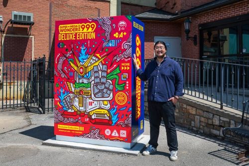 Artist Jordan Wong (WONGFACE) with his latest creation—a Little Free Library and public art piece, “Super Mega Wonder 1999,” located outside Asia Town Center at 3820 Superior Ave.