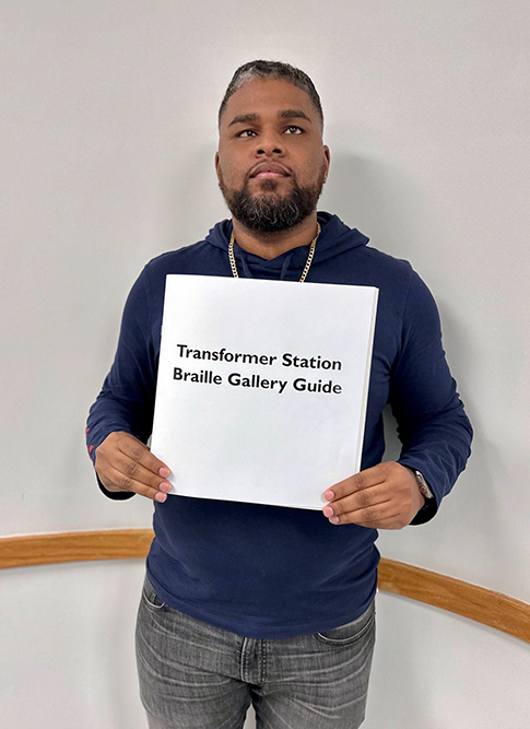 Brian Anderson, Arts & Accessibility Coordinator, Clovernook Center for the Blind & Visually Impaired, with a Braille Gallery Guide produced for FRONT 2022