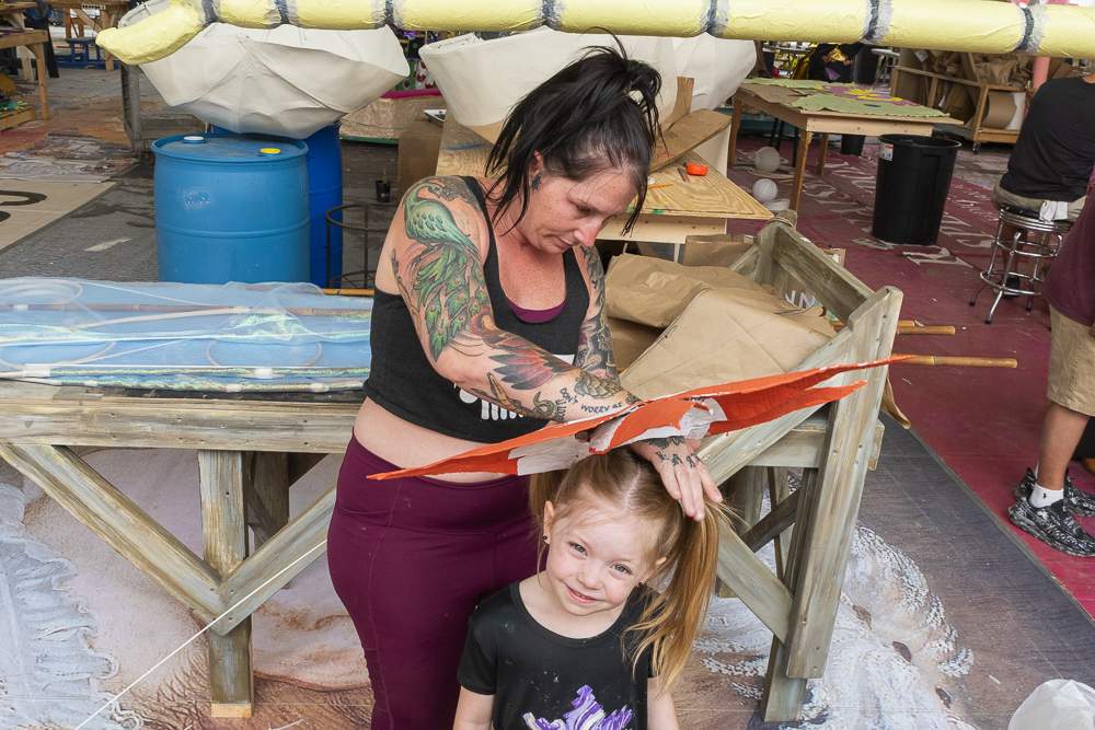 Artist Ashley Wischmeier adjusting a costume on her daughter Lily