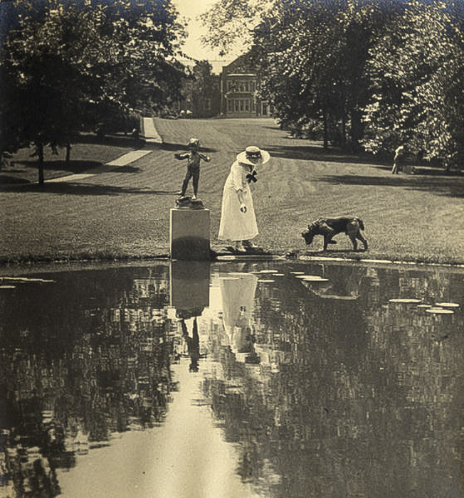 Elisabeth Severance Allen Prentiss pictured with a dog behind the lily pond on the grounds of Glen Allen