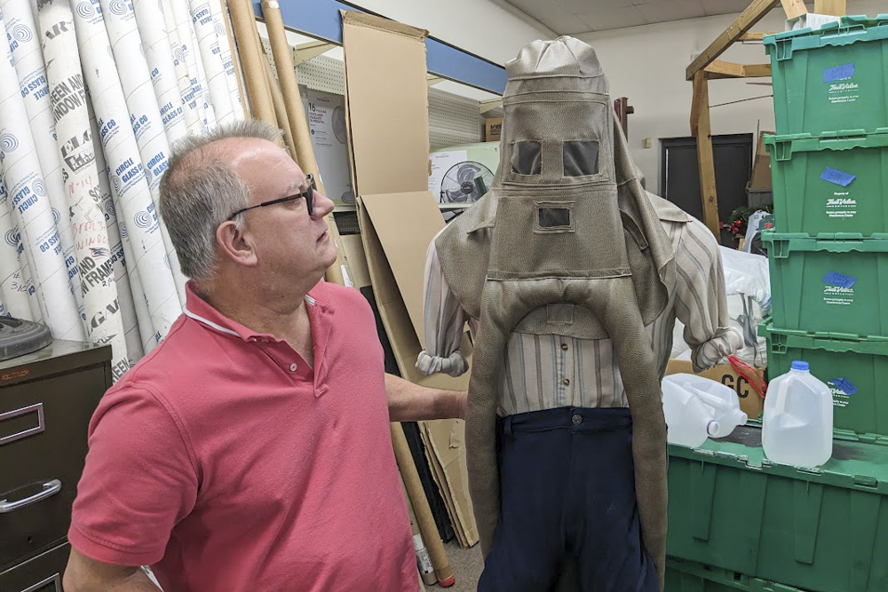 Bill Henrich, president of the Willoughby Historical Society, with a replica of Garrett Morgan's safety hood. Photo by Grant Segall.
