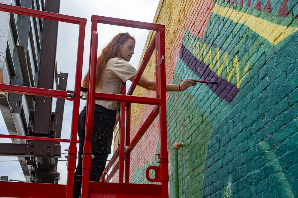 Tesa La Baron painting the Guatemala mural
