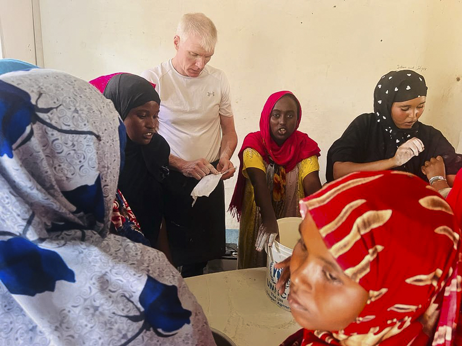 Brandon cooking with the villagers in Ali Adde