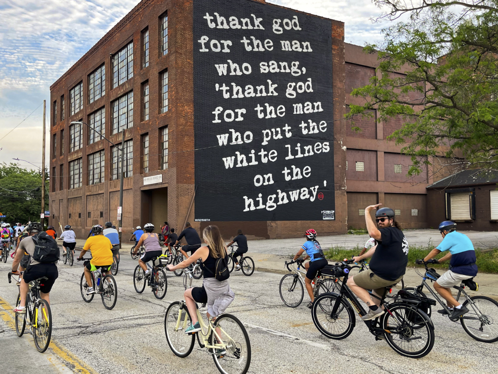 Slow Roll riders pass the Michael Stanley mural on Payne Ave. in Midtown