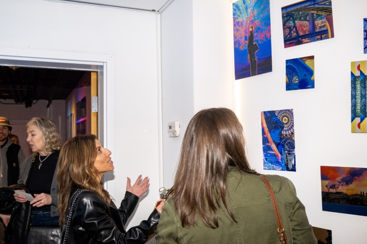 Guests view a selection of Toth's work at the March gallery opening.