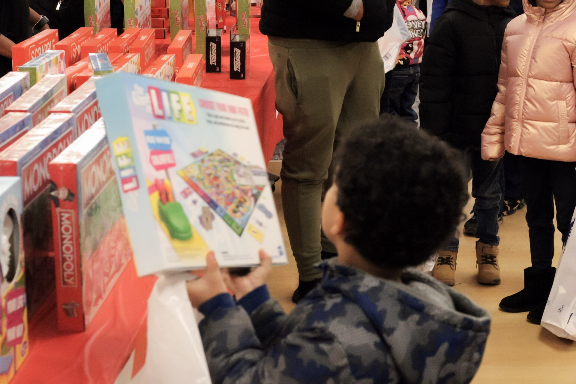 A young boy chooses a Game of Life board game.