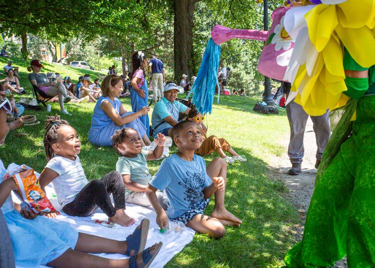 A flower waters a group of amused kids.
