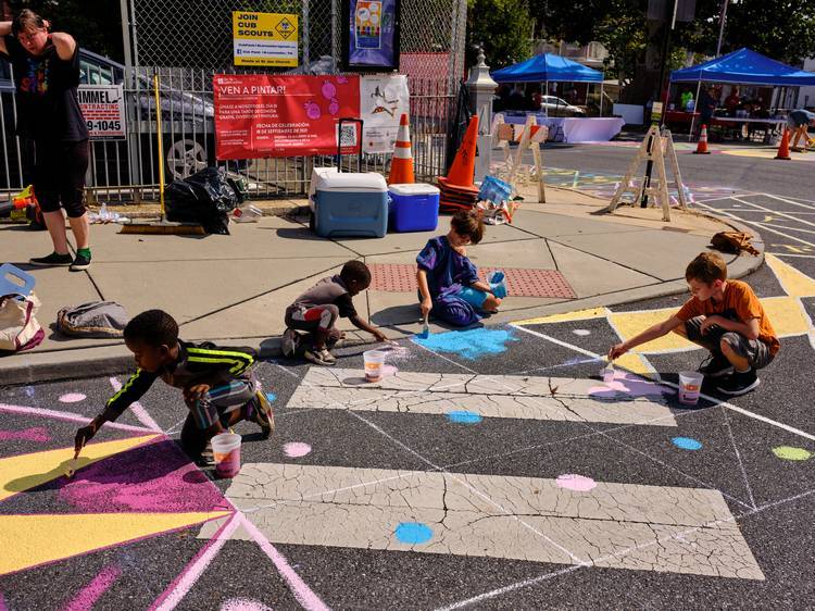 Local artists and citizens paint an Asphalt Art mural in Lancaster, Pennsylvania in 2021.