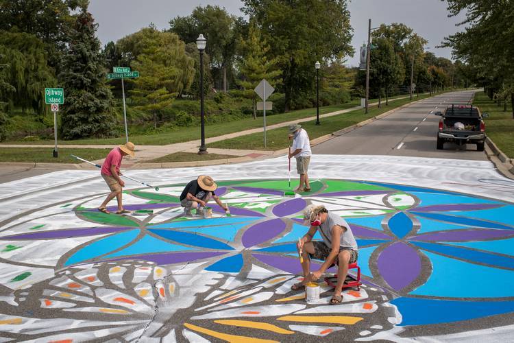 People paint at the intersection of Ezra Rust Avenue and Fordney Street during the Great Mural Project Asphalt Mural Paint-A-Thon on Sept. 26, 2020 in Saginaw, Michigan. (Photo by Nic Antaya/Bloomberg Philanthropy)