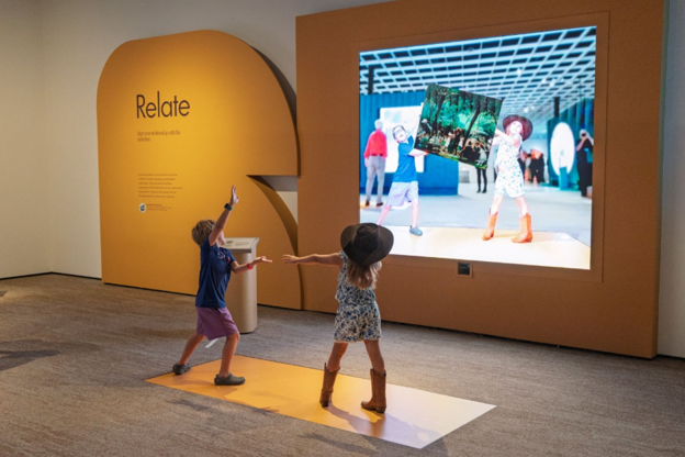 Two children work together to 'hold' the artwork at  'Art in Arms Reach.'