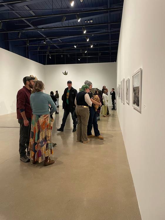 Guests mingle and study the four exhibits at moCa's recent 2026 season opening event.