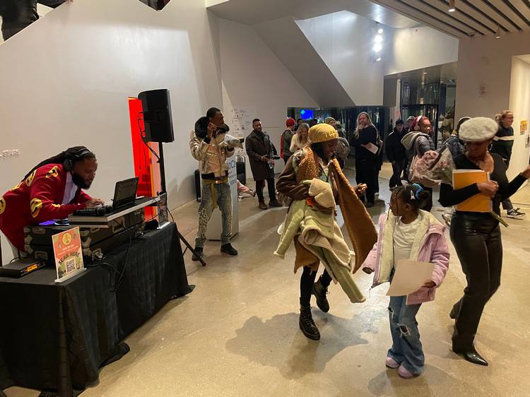 Pausing to enjoy DJ Silk at Visitors study the work of Akron artist Avery Mags Duff at moCa Cleveland's 2026 season opening event..