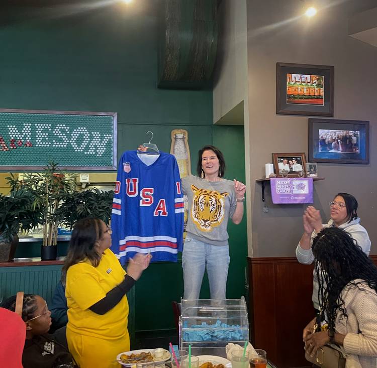 Krissy Dietrich-Gallagher prepares to draw a name in Heights Athletics Boosters raffle for an Edwards autographed jersey.