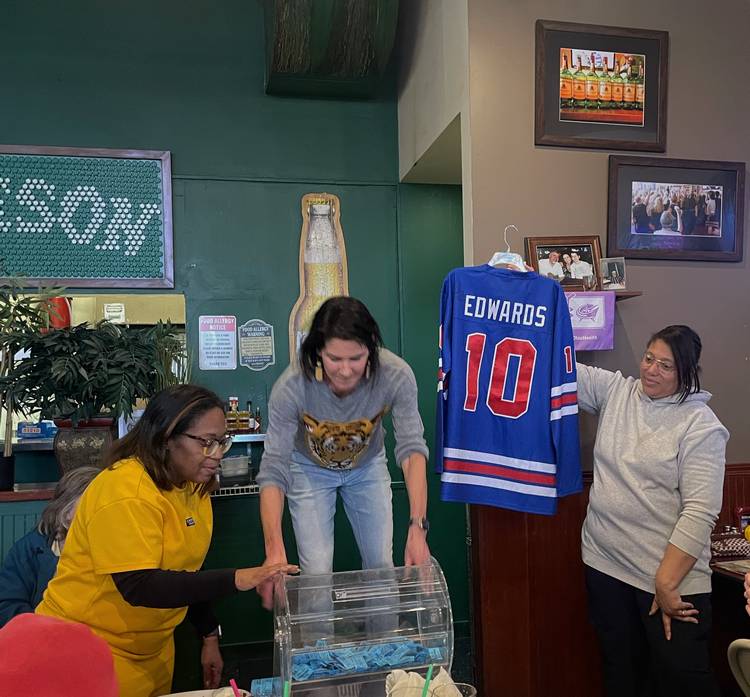 Krissy Dietrich-Gallagher draws a name in Heights Athletics Boosters raffle for an Edwards autographed jersey.