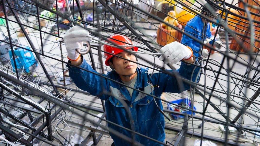 A Tianyu lighting and kinetic designer works on a lantern.