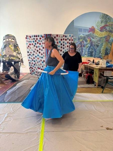 Parade artists and volunteers try on different costumes.