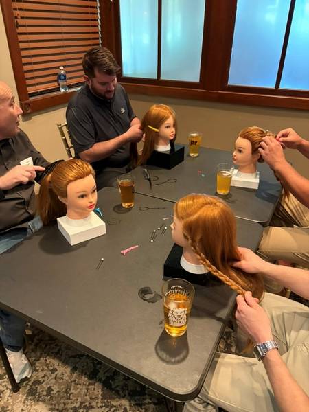 Fathers earning to braid hair during a Pints and Ponytails practice run at StoneWater.