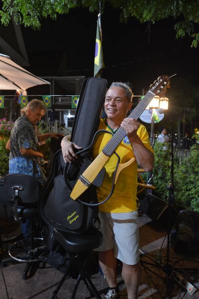 Moises Borges displaying his guitar, with a smile.