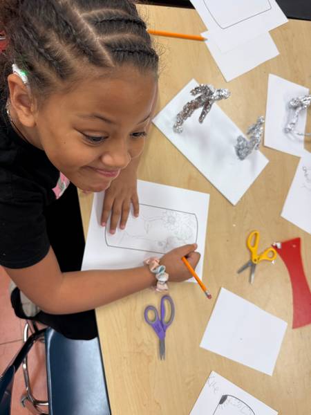 Students first drafted their design ideas on paper before drawing them on the barrels.