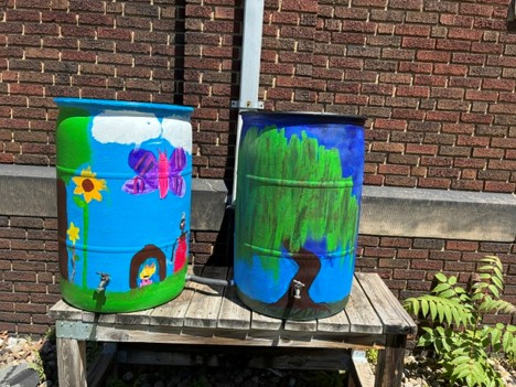 Left, Two deaf third graders designed the barrel that was painted by the rest of the class. Right, two 7th graders depict a weeping willow giving life (water).