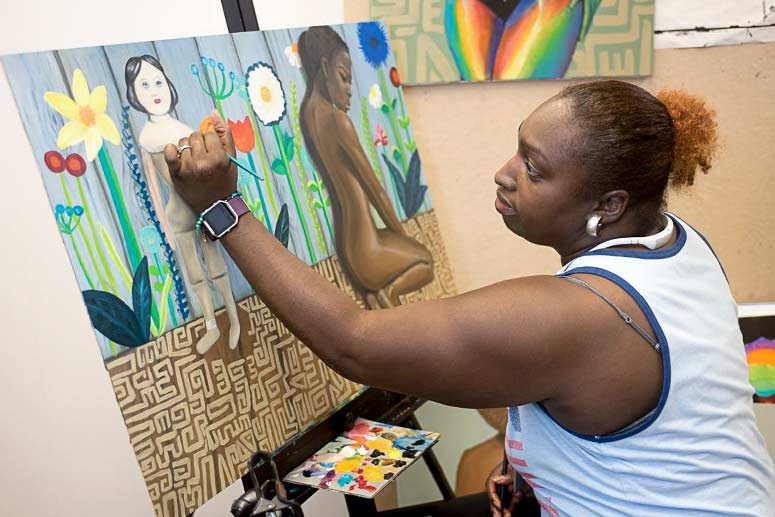Artful Cleveland artist LaSaundra Robinson works on painting in her studio.