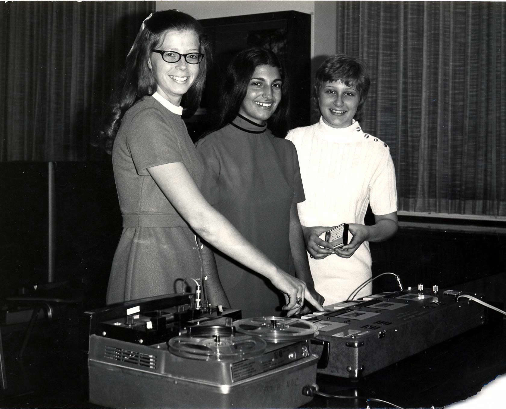 Chris Piatak '72, Terri Greco '75, and Vaunita Nash '75 examine a master tape duplicator in the Multimedia Learning Center in the 1970s.