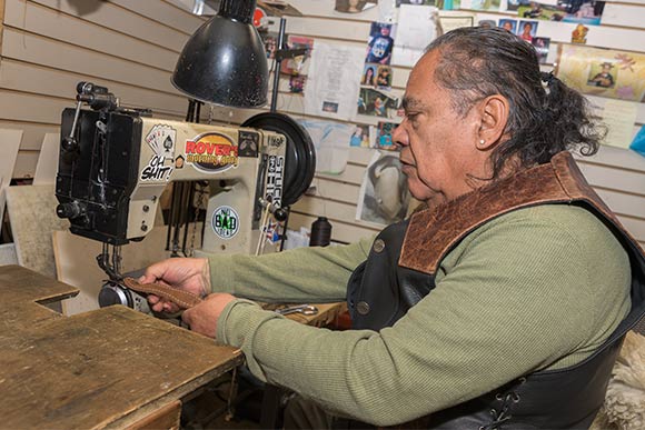 Chuck Perez sewing at the shop
