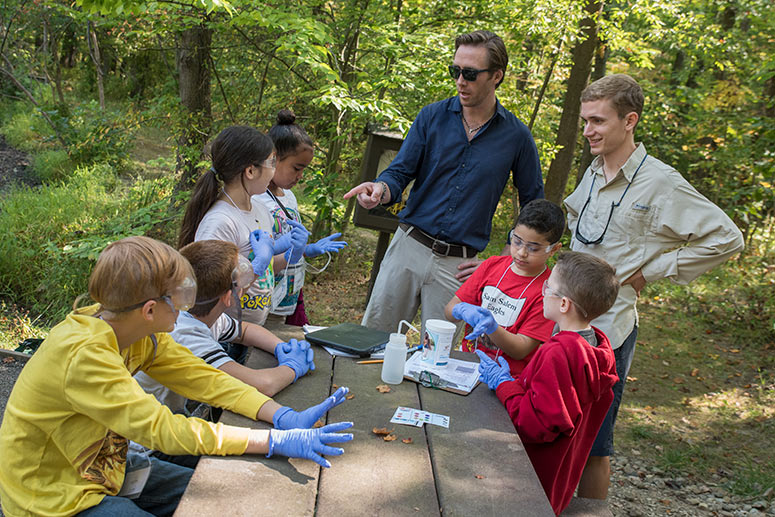 Cousteau with students water testing at the Environmental Education Center