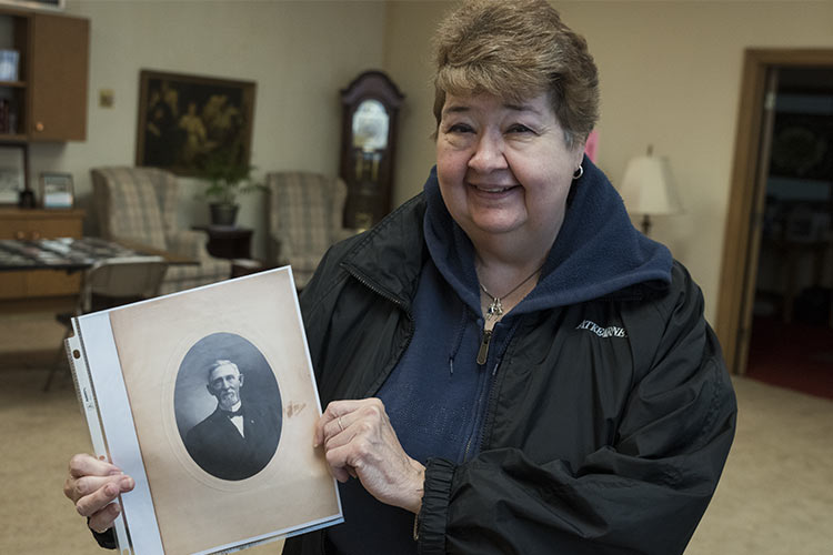 Lou Goodwin holding a photo of her grandfather, Leonard Fish