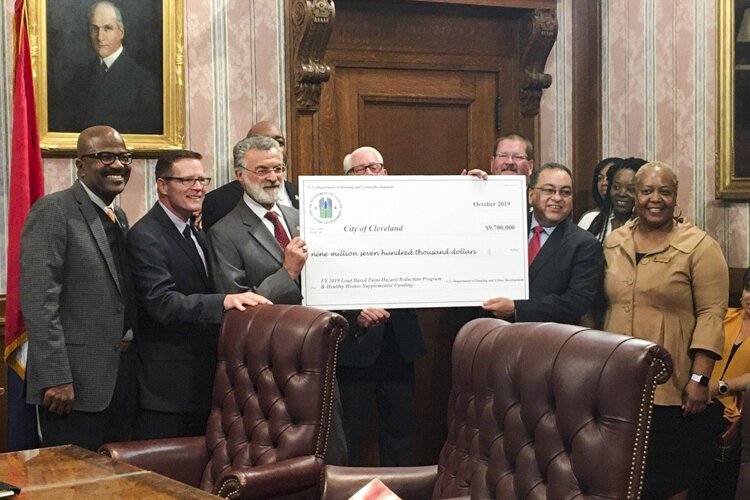 Mayor Frank Jackson stands with Joseph Galvan, regional administrator of the U.S. Department of Housing & Urban Development, and Kevin Conwell, Ward 9 councilman, to receive a check for $9.7 million for Cleveland’s lead crisis.