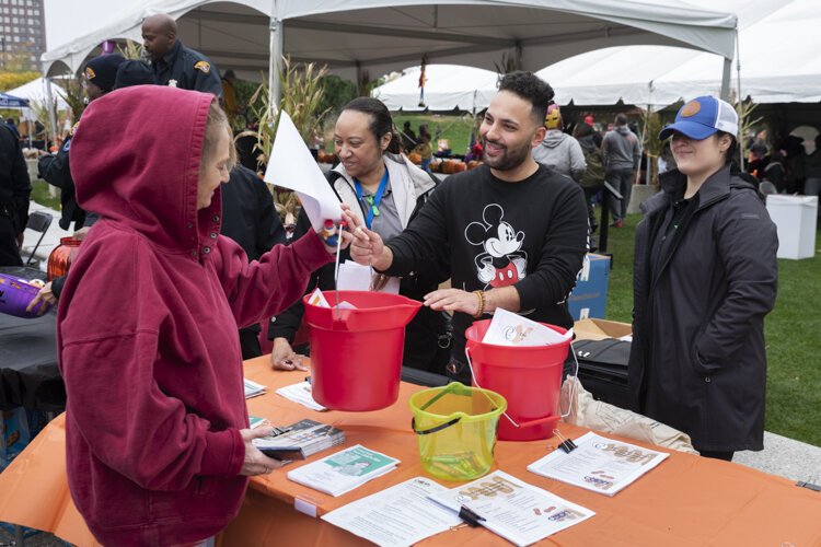 City of Cleveland Department of Public Health worker Abraham Enais gives out a lead poisoning cleanup bucket of supplies at a recent event in Public Square.