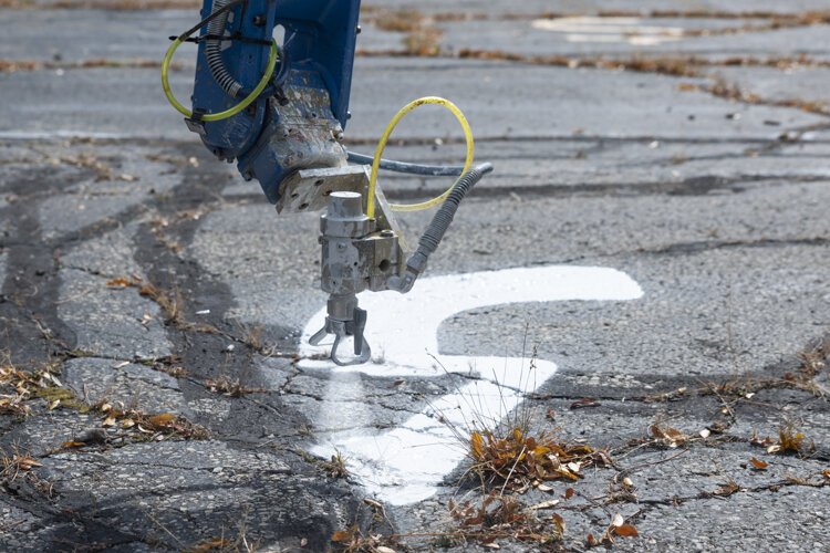 The robotic arm spraypaints an arrow during a recent test in Cleveland Heights.