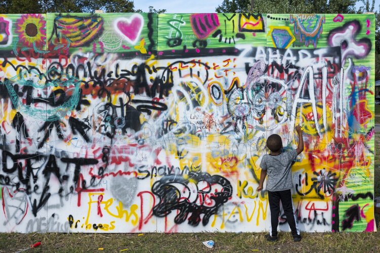A child adds to a group mural at Fresh Fest 2019