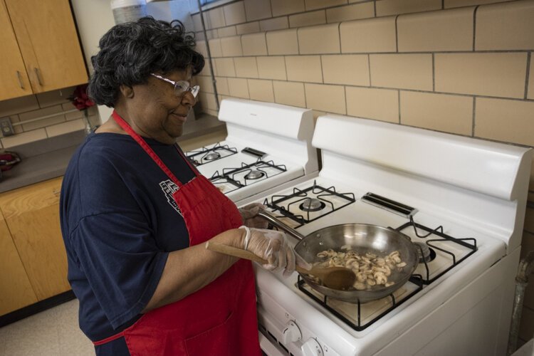 A Cedar High Rise senior sautees some mushrooms for a healthy quiche.