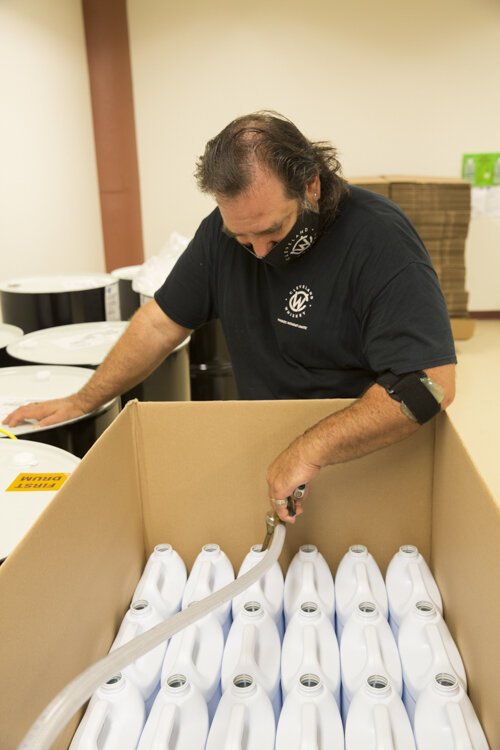 Filling bottles of hand sanitizer at Cleveland Whiskey