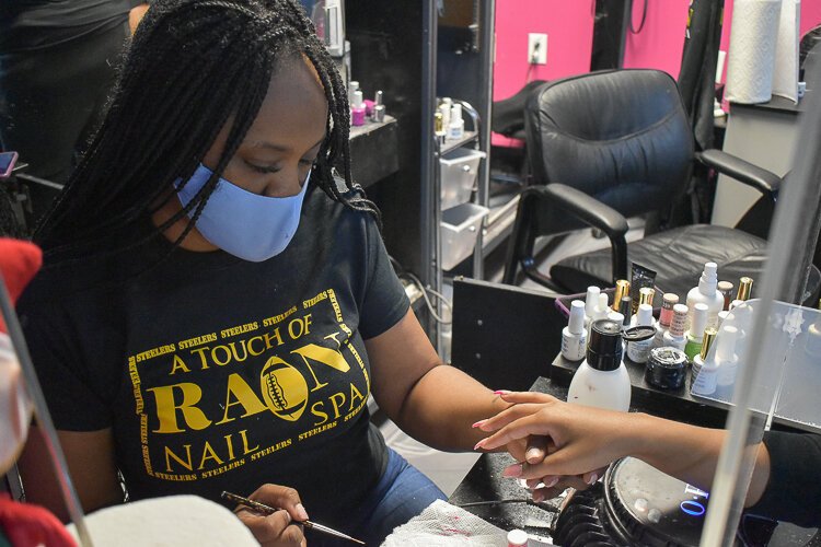 Rain Burnside, owner of A Touch of Rain Nail Spa in Larchmere,  provides a manicure to a client during a November event meant to educate people on the Child Tax Credit.