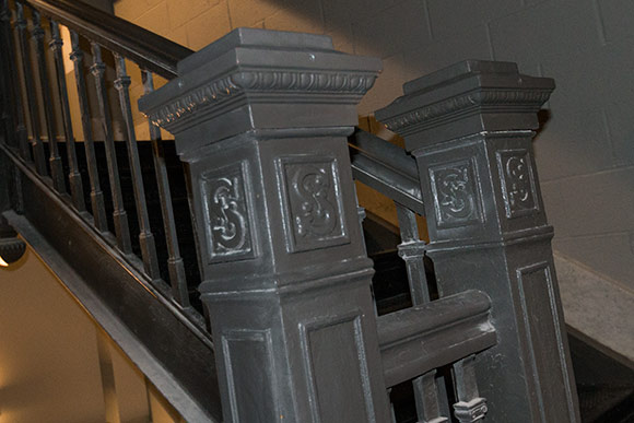 The center staircase that runs throughout the building and features Schofield’s signature “S” on each newell post