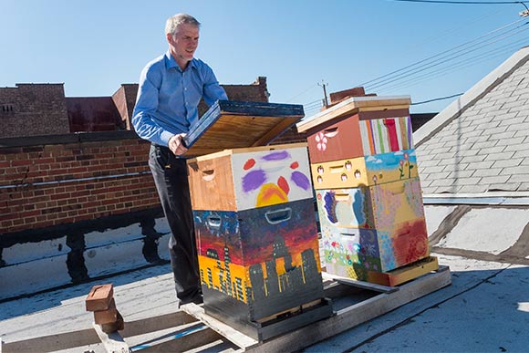 Brandon Chrostowski checking the roof top bee hives