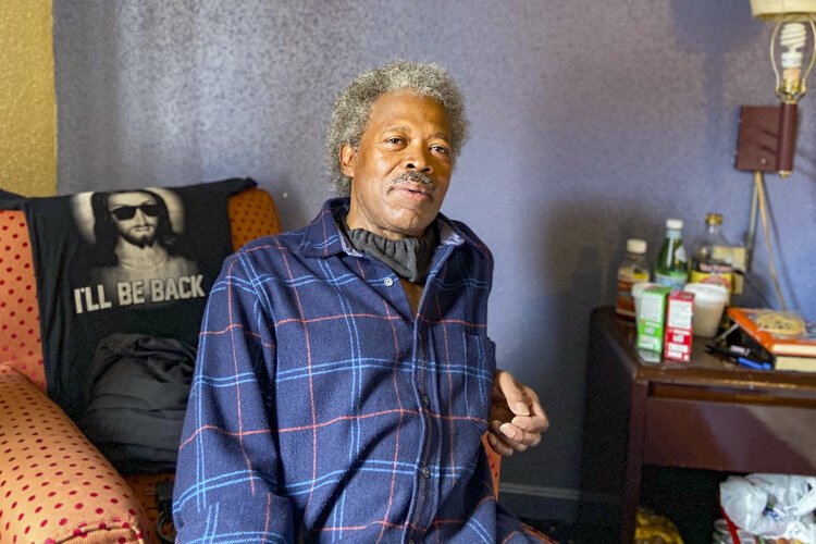 Abel Currie, 63, sits in his hotel room in May. It’s been a relief for him to have space to quarantine safely as he searches for a permanent apartment.