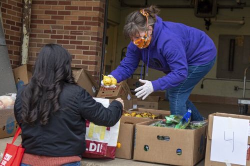 Cassie Pegg-Kirby, Director of the Women’s Center at Kent State, distributes donated food on the loading dock at Beall Hall where it will be given to local families who find themselves in need during the Covid-19 crisis.