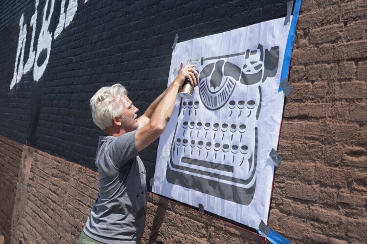 Cleveland native and Los Angeles-based street artist WRDSMTH putting his signature on the “Lover” Micheal Stanley tribute mural on Payne Ave.