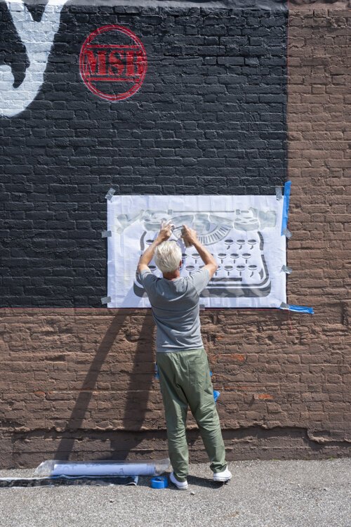 Cleveland native and Los Angeles-based street artist WRDSMTH putting his signature on the “Lover” Micheal Stanley tribute mural on Payne Ave.