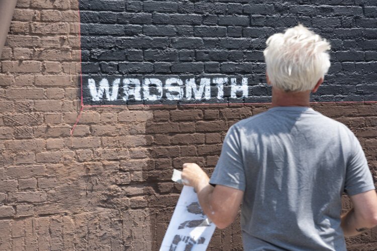 Cleveland native and Los Angeles-based street artist WRDSMTH putting his signature on the “Lover” Micheal Stanley tribute mural on Payne Ave.