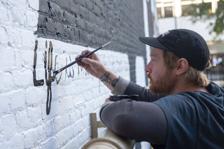 Alan Giberson of the Old Soul Sign Co., working on the restoration of the mural.