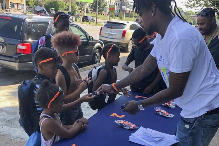 Craven Smith gives kids wristbands and sunglasses with anti-bullying messages on them.
